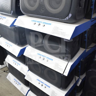 Onn Large Party Speaker store display, featuring multiple units. Labeled details include FM radio, bass boost, water-resistant design.