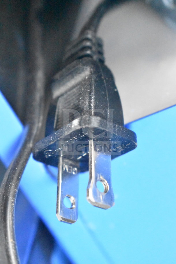 Close-up of a standard black electrical plug attached to a cord, used for connecting electronic devices such as speakers.
