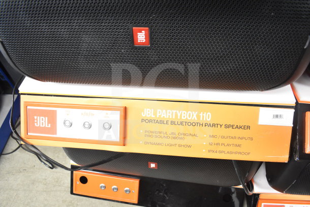 JBL Partybox 110 speaker display. Features: 160W sound, dynamic light show, mic/guitar inputs, 12hr playtime, IPX4 splashproof.