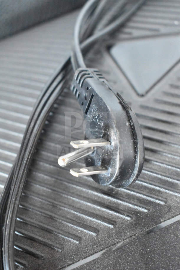 Close-up of a power plug on a ribbed surface, part of JBL Partybox 110 display.