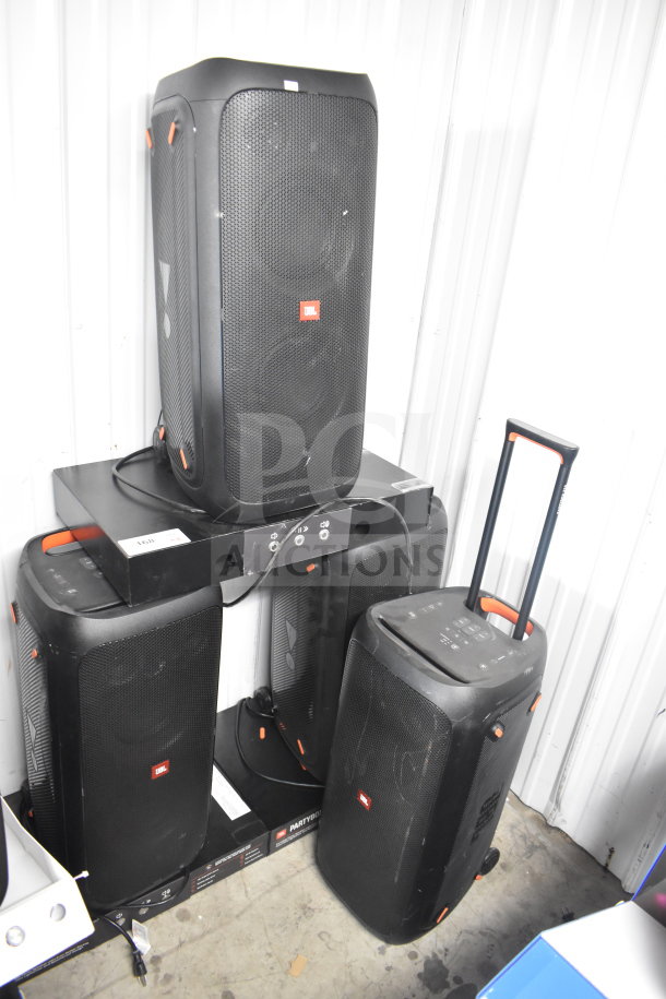 Four JBL Partybox 310 speakers with visible controls and handles, used condition, offering powerful audio output.