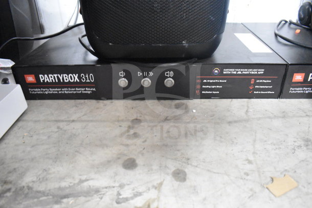 JBL Partybox 310 speaker store display featuring pro sound, dazzling light show, splashproof design, and multiple inputs.