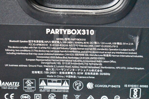 JBL Partybox 310 label showing model specifics, power input 100-240V, FCC ID, made by Harman International Industries.