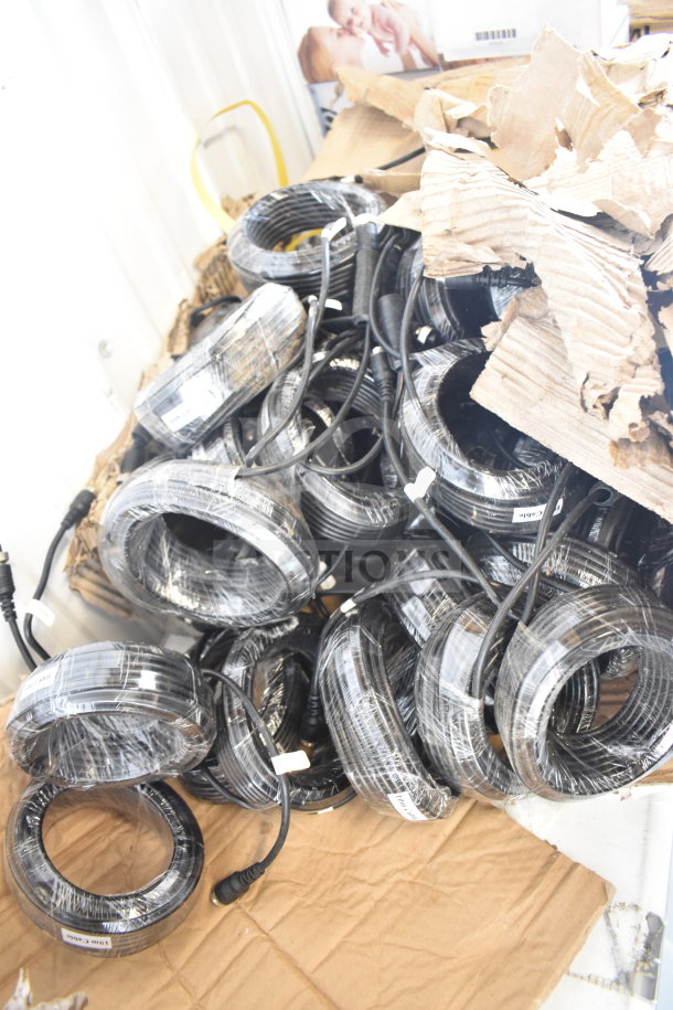 Box of 10m cables, wrapped and labeled, in new condition, bundled on a cardboard sheet.