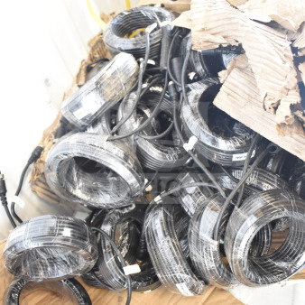Box of 10m cables, wrapped and labeled, in new condition, bundled on a cardboard sheet.