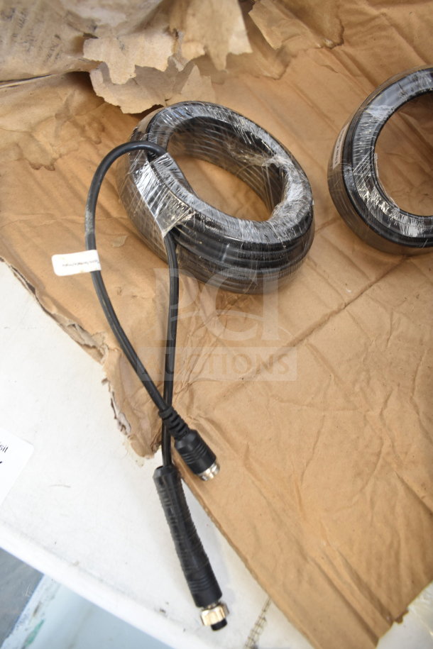 Coiled 10m cable wrapped in plastic on cardboard, black connectors visible, in new condition.