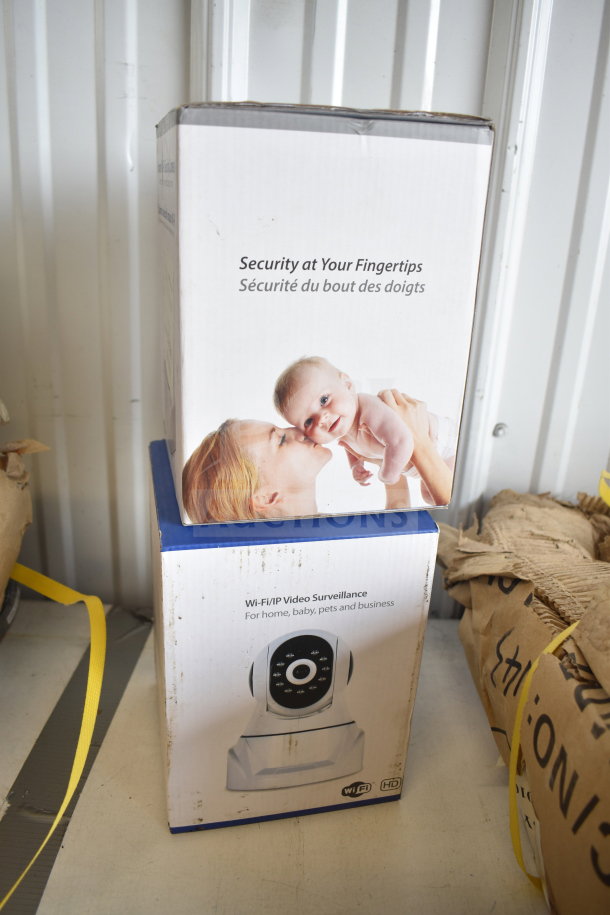 Two Wi-Fi video surveillance cameras in original boxes; includes home, baby, pets, business monitoring features. New condition.