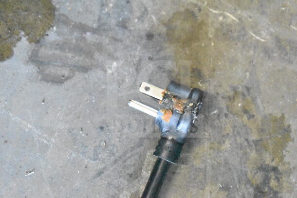 Damaged power plug of 2019 True GDM-72-HC cooler, showing burnt marks, indicates need for repair.