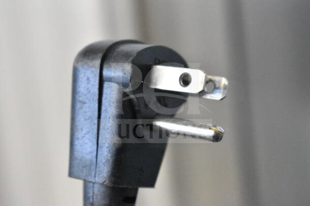 Close-up of a standard three-prong electrical plug connected to the 2024 Hoshizaki AM-50BAJ-DS icemaker, missing the door.