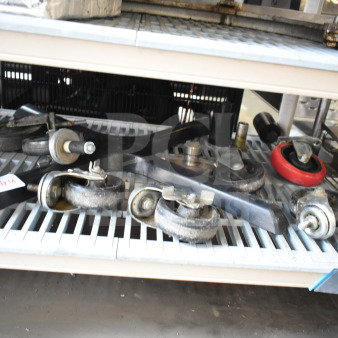 Various items including commercial casters and a table base piece on a metal shelf, items are in used condition.
