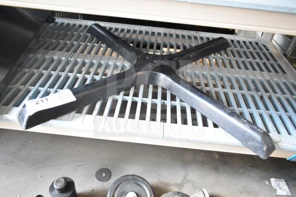 Black table base piece with tag labeled "211 VX10" on metal shelf; includes additional casters and components.
