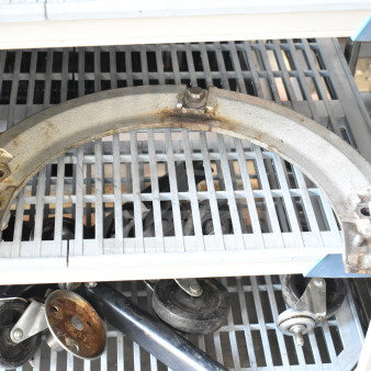 Commercial mixing bowl adapter, metal, used condition, slight rust, resting on metal shelving, auction tag visible.