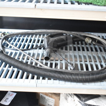 Vacuum hose attachment with black handle, coiled hose, and various connectors in good condition on wire shelf.