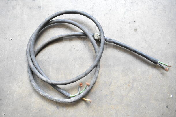 Vacuum hose attachment with visible wear, coiled on concrete. Ends show exposed wiring. Sold as part of a three-item set.