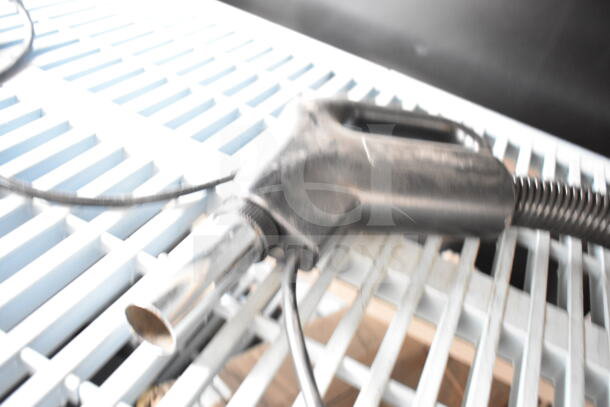 Vacuum hose attachment on white slatted surface, showing wear. Auction includes three items, increase bid for more value.