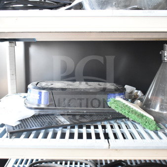 Assorted items including an espresso bean grinder hopper, slushie machine hopper lid, and dustpan broom on a shelf.