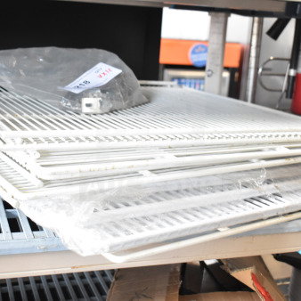 12 assorted items including stacked white racks, wrapped in plastic, on a metal shelf. Auction label on top.