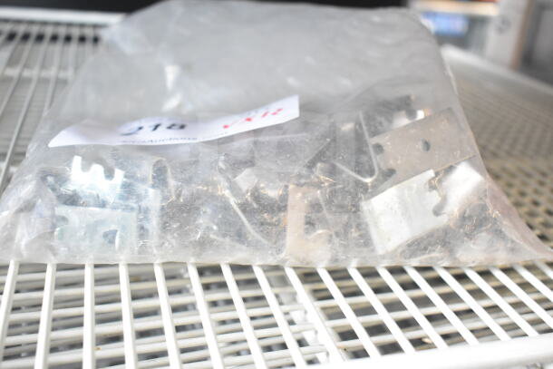 Clear plastic bag with metal brackets on white racks. Includes numbered auction tag. Good condition.