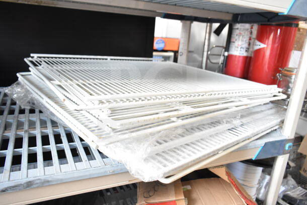 White metal racks stacked on a shelf, part of a lot of 12 various items. Racks appear to be in used condition.