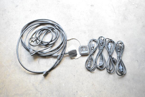 Six various cords, including power and audio cables, bundled on a concrete floor. Features a control pad.