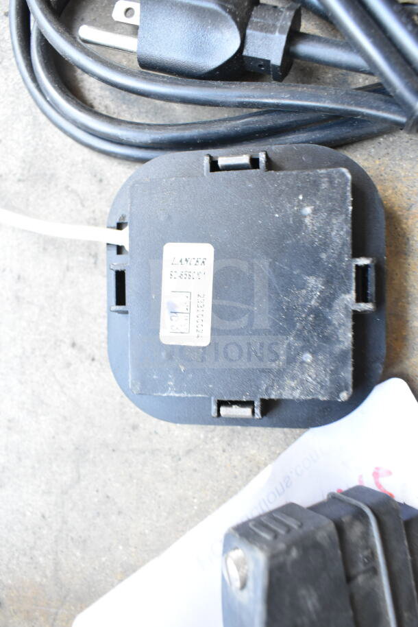 6 various electronic items with cords, including a Lancer SE-599CM1 device, visible wear, and assorted plugs.
