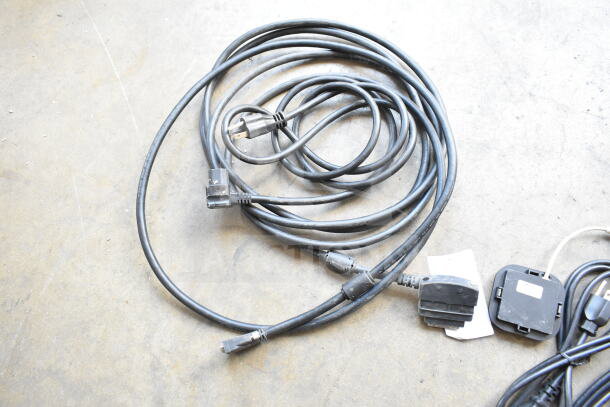 A collection of six assorted black power cords, including plugs, connectors, and tags. Good condition, multiplies bid.