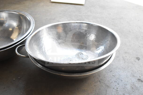 5 metal bowls and an Azzurra pizza peel set on a surface. Bowls show a shiny finish; ideal for culinary use.