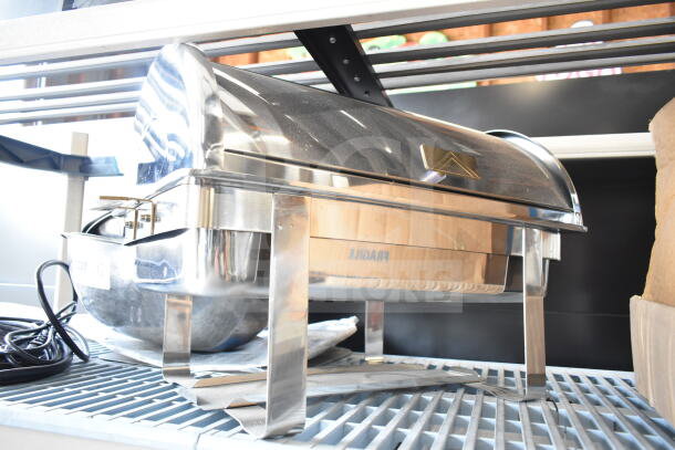 Stainless steel countertop roll top chafer with polished finish, visible sturdy legs, and a sleek lid design.