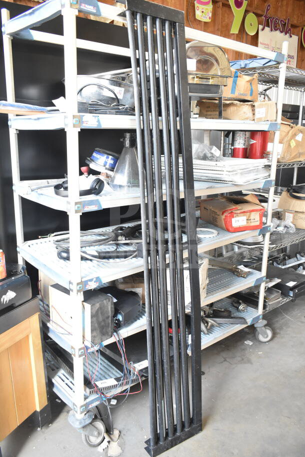 Black metal cooler kickplate, long and vertical, resting against industrial shelving. Appears in good condition.