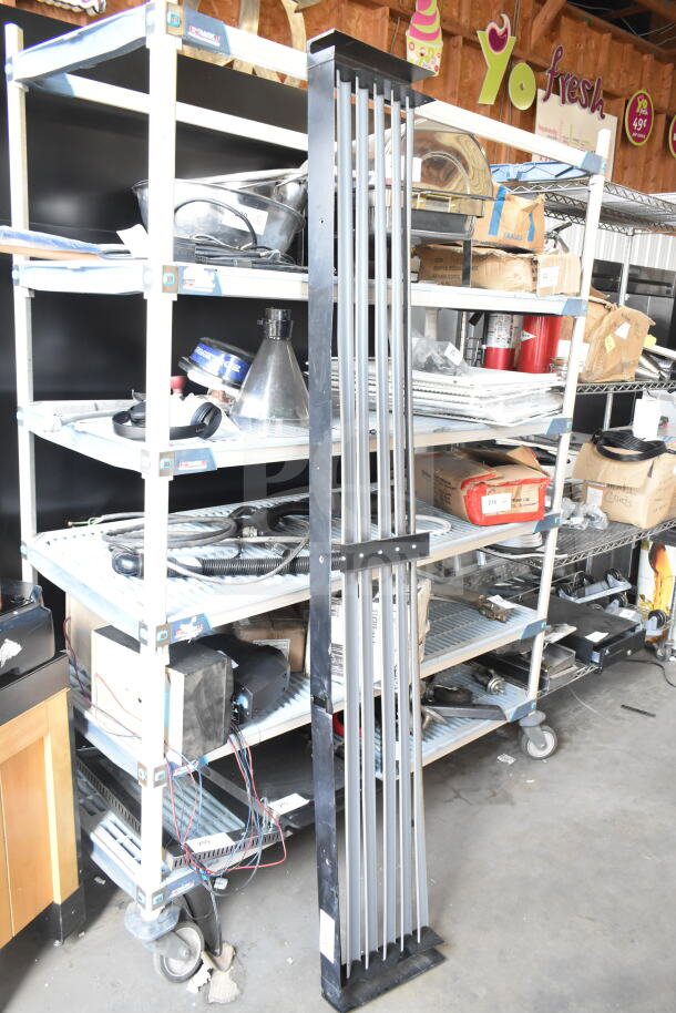Metal cooler kickplate, black and silver with vertical slats, shown in good condition, standing upright near shelving.