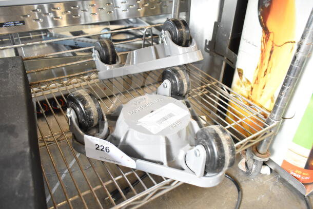 2 862330DOLLYPH Bond 750 lb. cast steel triangular cup dolly with phenolic casters on metal rack. Label reads "226".