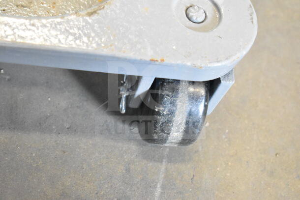 2 862330DOLLYPH Bond 750 lb. cast steel triangular cup dolly with phenolic casters, visible wear, industrial use.