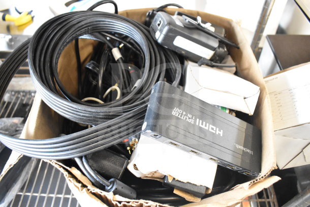 Box with HDMI splitter, various cables, and electronics, includes Blackweb HDMI splitter 1 in 4 out, appears in used condition.