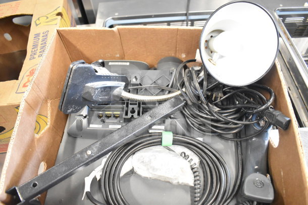 Box of six various office items including a corded telephone, flexible desk lamp, and assorted cables. Mixed condition.