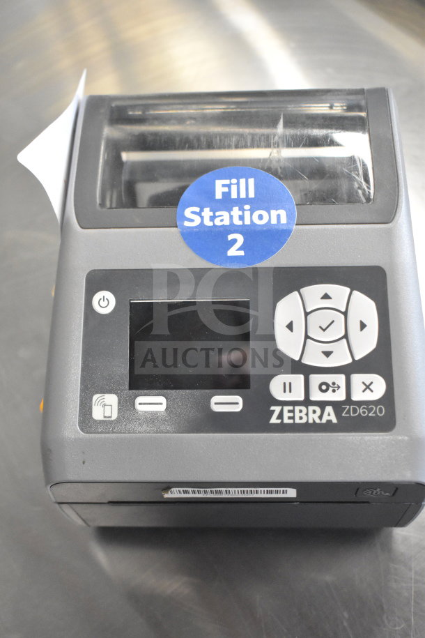 Zebra ZD620 desktop direct thermal barcode printer. Features control panel, media sensor. Marked "Fill Station 2." Good condition.