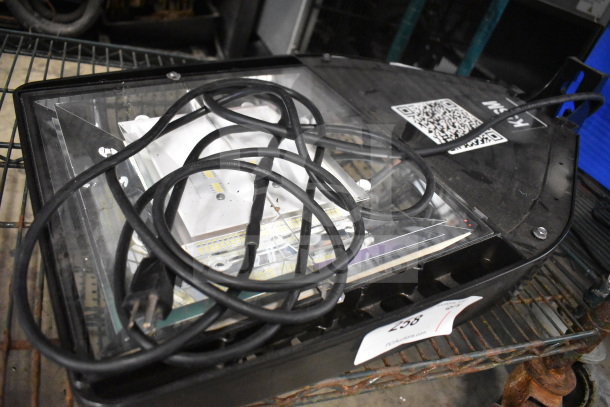 Black light fixture with clear lens, attached power cord, and visible QR code on casing. Auction tag reads "258".
