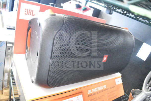 JBL PartyBox 110 speaker on store display, featuring robust black design, prominent JBL logo, and control buttons.