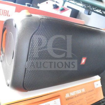 JBL PartyBox 110 speaker on store display, featuring robust black design, prominent JBL logo, and control buttons.