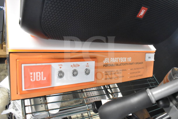 Store display featuring JBL Partybox 110 speaker with Bluetooth, 160W sound, dynamic light show, and splash-proof design.