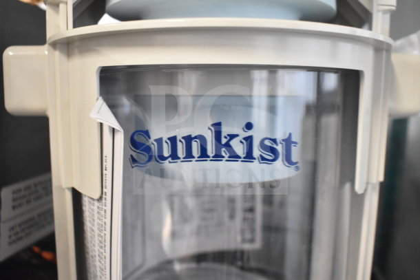 BRAND NEW Sunkist CCP27 Countertop Juicer with minor scratches, clear plastic casing, Sunkist logo visible.