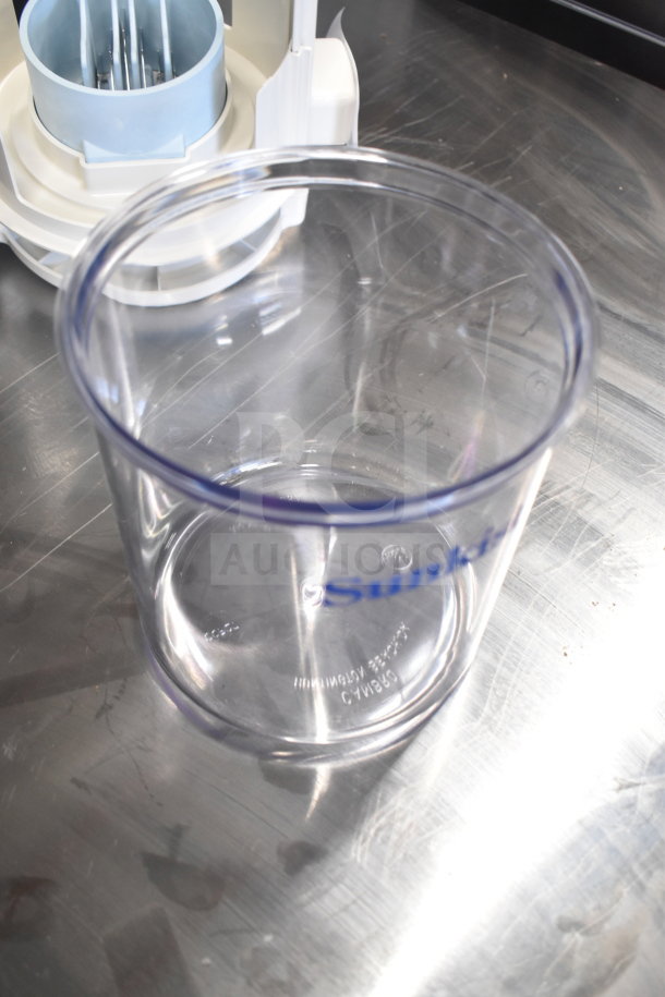 Brand new Sunkist CCP27 countertop juicer, visible minor scratches on the container, clear plastic with blue logo.