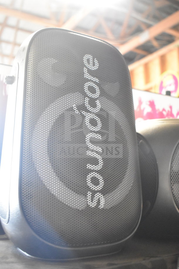 Soundcore speaker store display, black mesh grille with logo. Compact design, ideal for retail settings. Good condition.