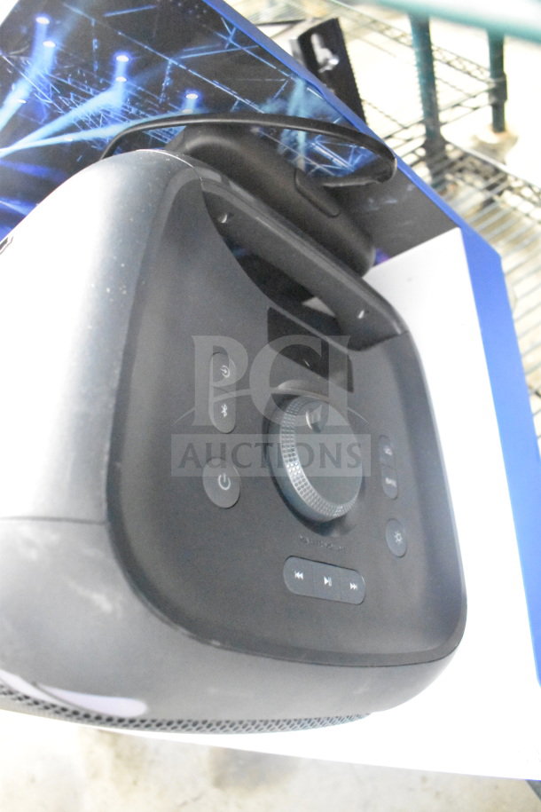 Store display with Onn large party speaker, featuring control panel, volume dial, and sturdy handle. Appears in used condition.