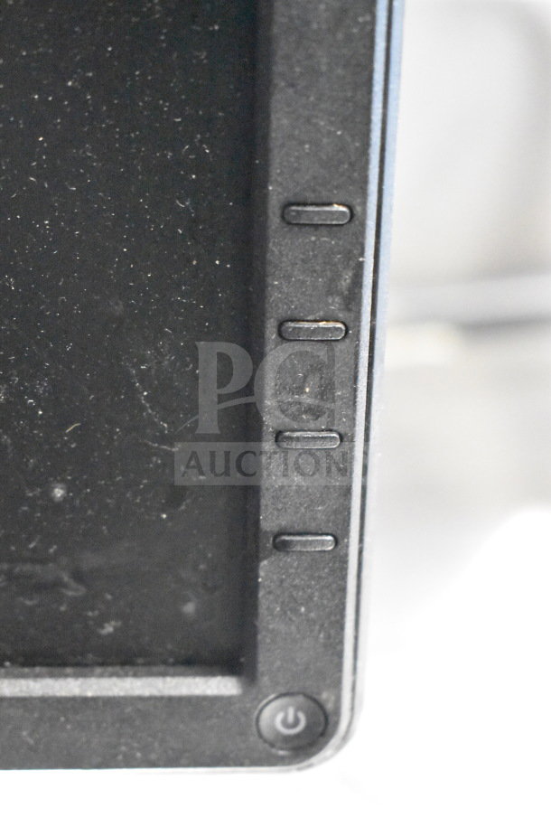 Close-up of a computer monitor's control buttons and power button. Dust visible on the screen edge. Brand not specified.