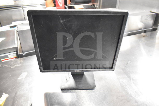 Dell computer monitor, black, on a stand. Visible scuffs and dust on the screen. Included in 6 monitor auction lot.