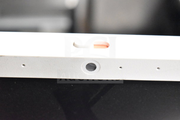Alt text: Close-up of a white monitor frame featuring a camera and sensors. Condition appears used. Part of a 6-monitor auction lot including Dell and HP brands.