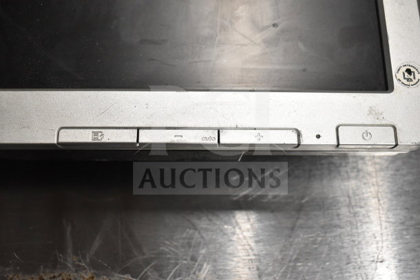 Close-up of a computer monitor's front panel with control buttons, including power and menu options. The screen has visible wear.