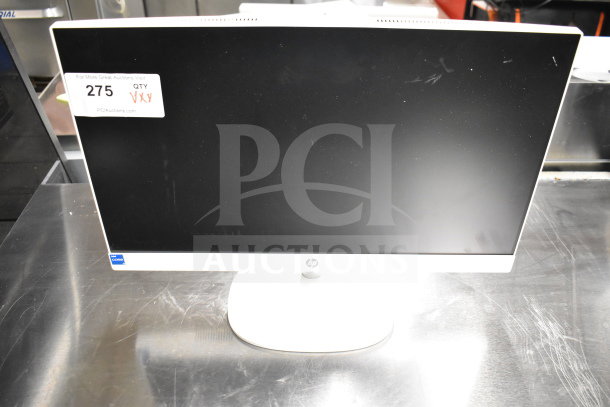 HP monitor with a white frame on a metal table, slight surface marks visible. Auction lot tag reads “275” and “QTY XXX.”