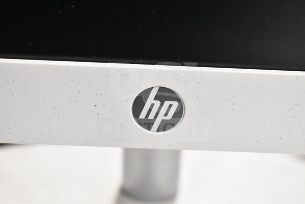 8 various monitors, including Toshiba, HP, and Onn. Close-up of HP logo on a white-speckled monitor bezel.