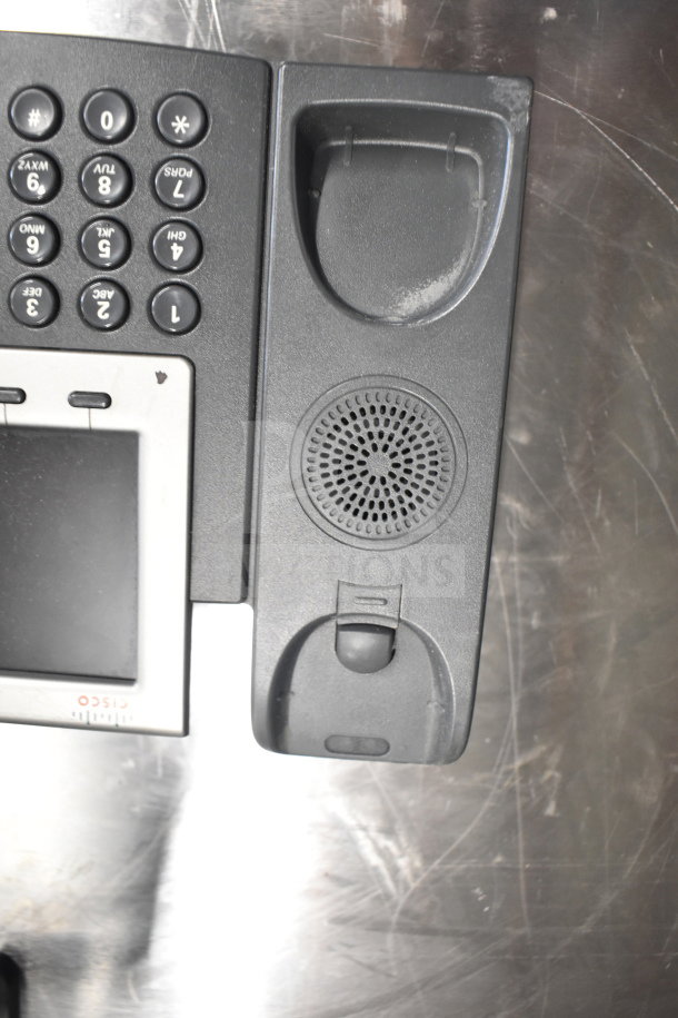 Office telephone with buttons and speaker on a metal surface, possibly part of a lot including monitors and receipt printers.